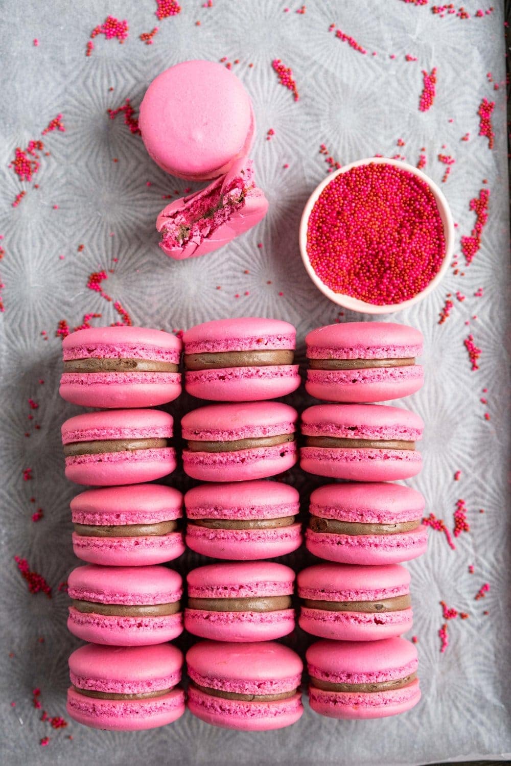 raspberry chocolate macarons on sheet pan