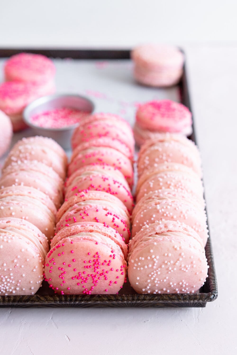 angle shot of macarons on a sheet pan with sprinkles