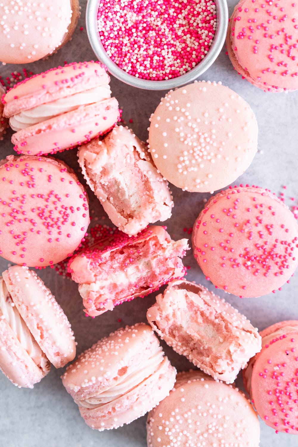 close up image of pink macaron shells with strawberry filling