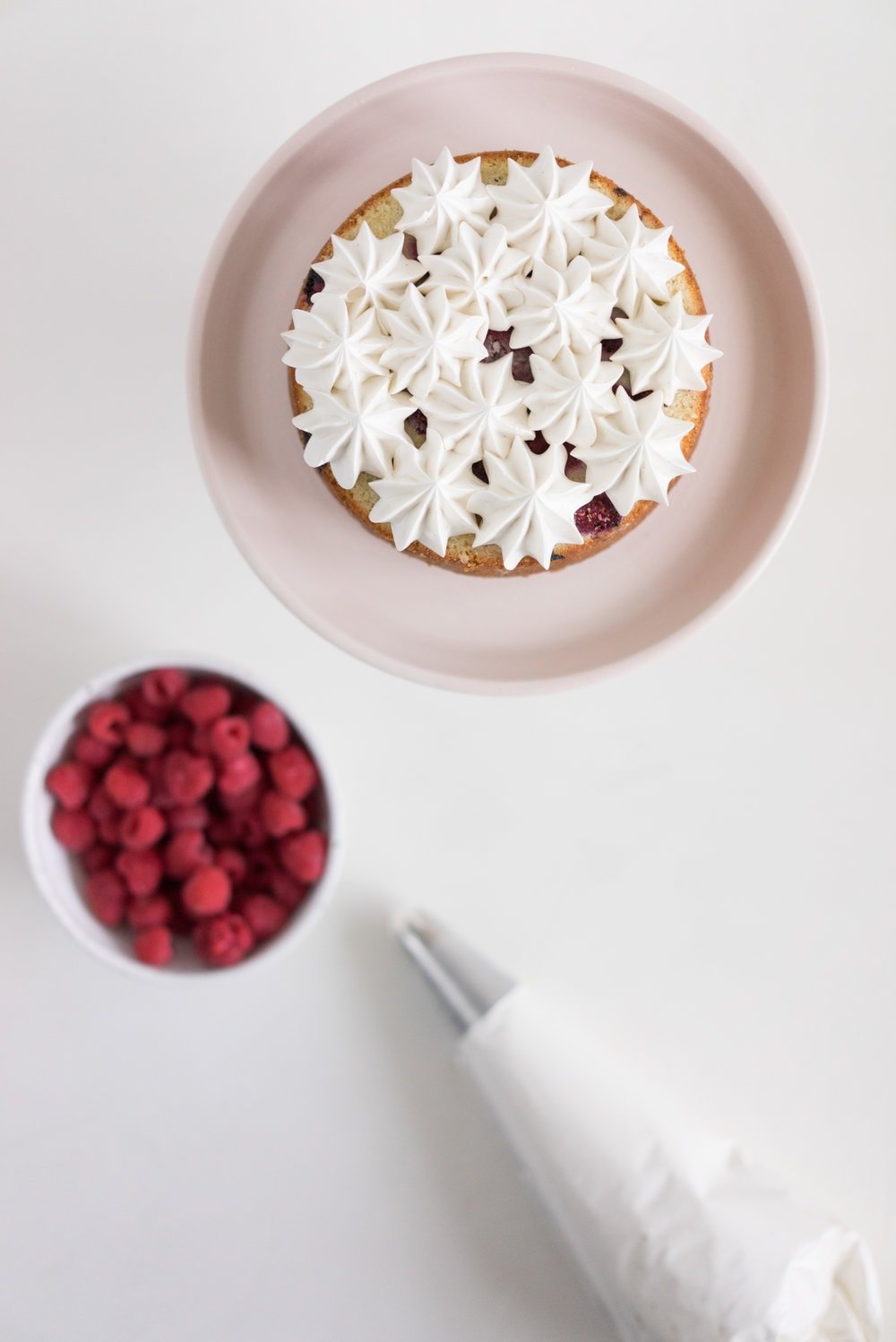 Raspberry and Almond cake - a perfectly dense almond meal cake, lightly scented with lemon, and with a layer of fresh raspberries baked into each layer. Layered with vanilla swiss meringue buttercream and more fresh raspberries. perfect for Mother's day or any other special occasion.
