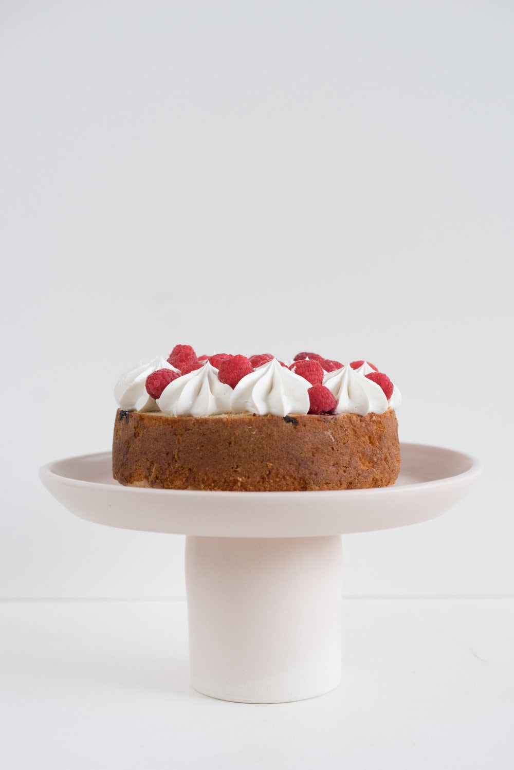 Raspberry and Almond cake - a perfectly dense almond meal cake, lightly scented with lemon, and with a layer of fresh raspberries baked into each layer. Layered with vanilla swiss meringue buttercream and more fresh raspberries. perfect for Mother's day or any other special occasion.