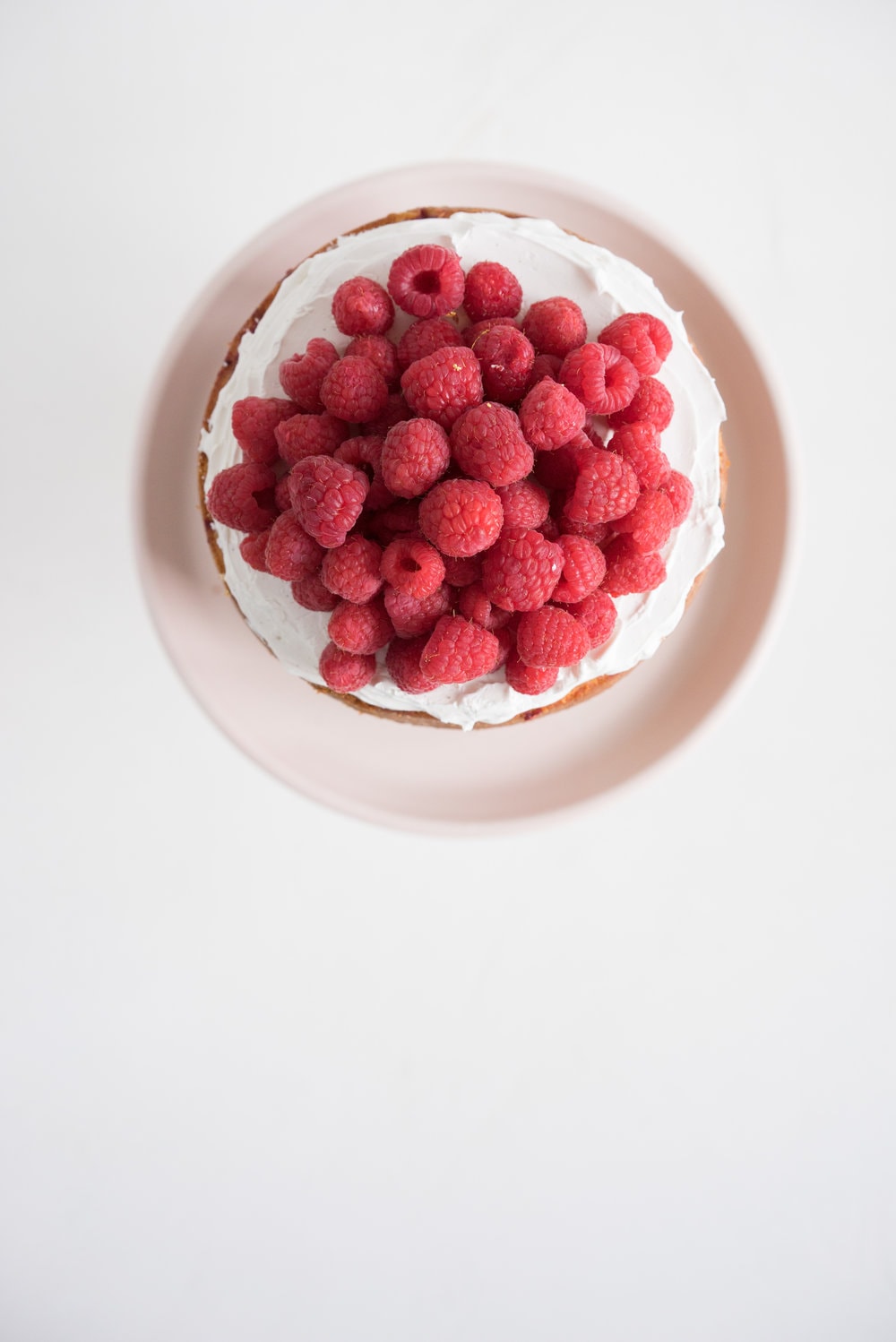 Raspberry and Almond cake - a perfectly dense almond meal cake, lightly scented with lemon, and with a layer of fresh raspberries baked into each layer. Layered with vanilla swiss meringue buttercream and more fresh raspberries. perfect for Mother's day or any other special occasion.