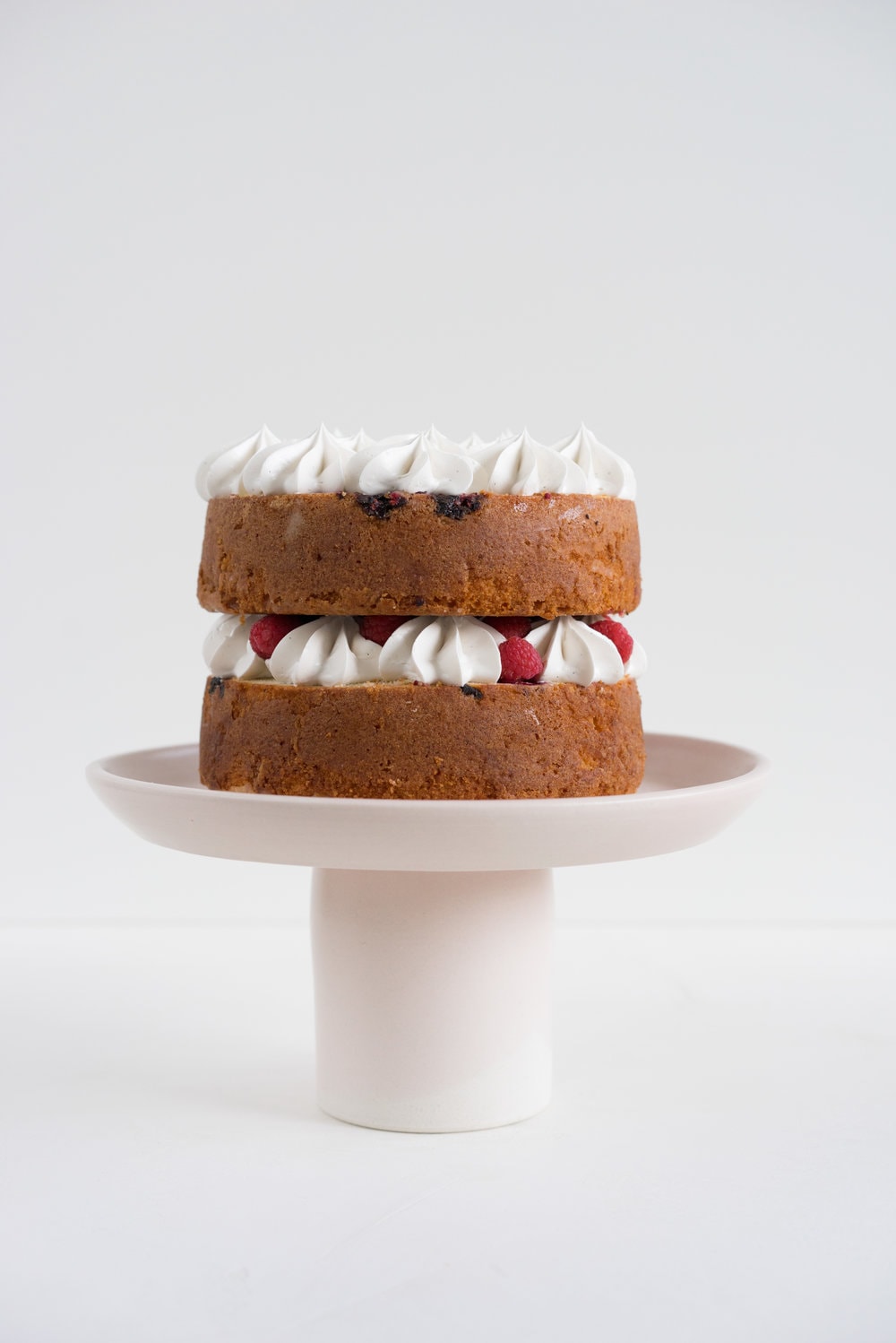 Raspberry and Almond cake - a perfectly dense almond meal cake, lightly scented with lemon, and with a layer of fresh raspberries baked into each layer. Layered with vanilla swiss meringue buttercream and more fresh raspberries. perfect for Mother's day or any other special occasion.