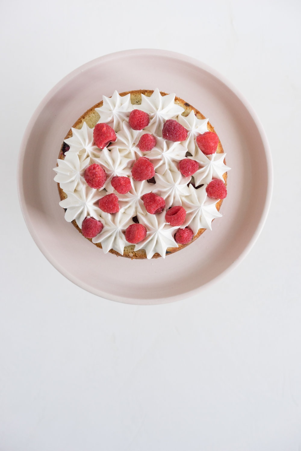 Raspberry and Almond cake - a perfectly dense almond meal cake, lightly scented with lemon, and with a layer of fresh raspberries baked into each layer. Layered with vanilla swiss meringue buttercream and more fresh raspberries. perfect for Mother's day or any other special occasion.