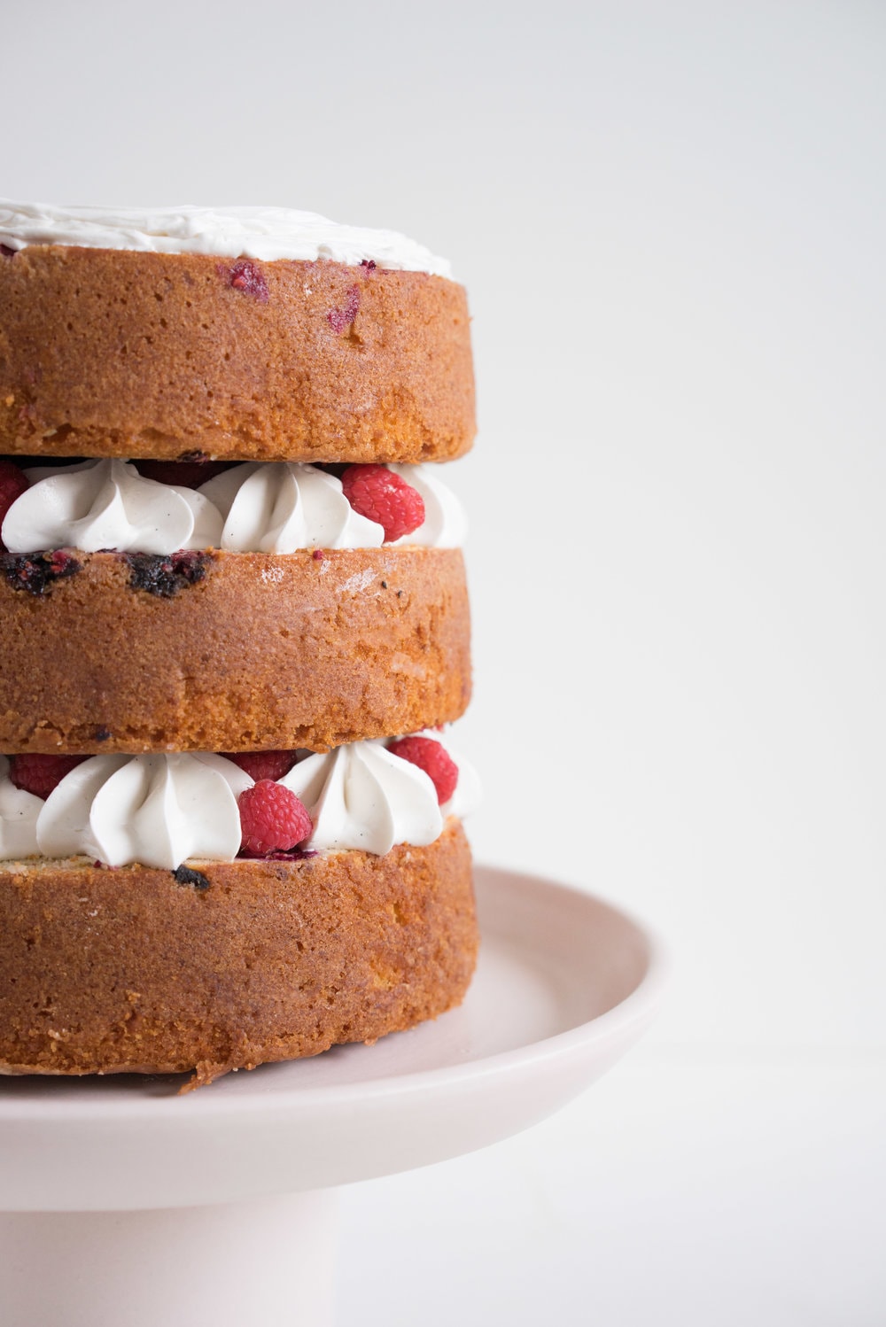 Raspberry and Almond cake - a perfectly dense almond meal cake, lightly scented with lemon, and with a layer of fresh raspberries baked into each layer. Layered with vanilla swiss meringue buttercream and more fresh raspberries. perfect for Mother's day or any other special occasion.