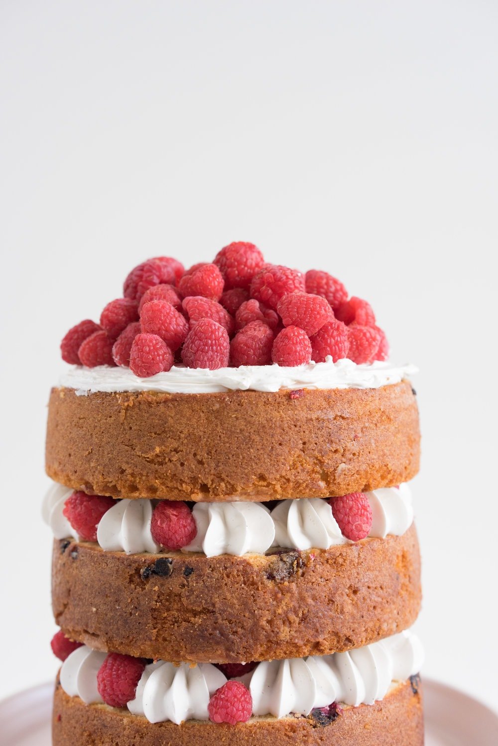 Raspberry and Almond cake - a perfectly dense almond meal cake, lightly scented with lemon, and with a layer of fresh raspberries baked into each layer. Layered with vanilla swiss meringue buttercream and more fresh raspberries. perfect for Mother's day or any other special occasion.
