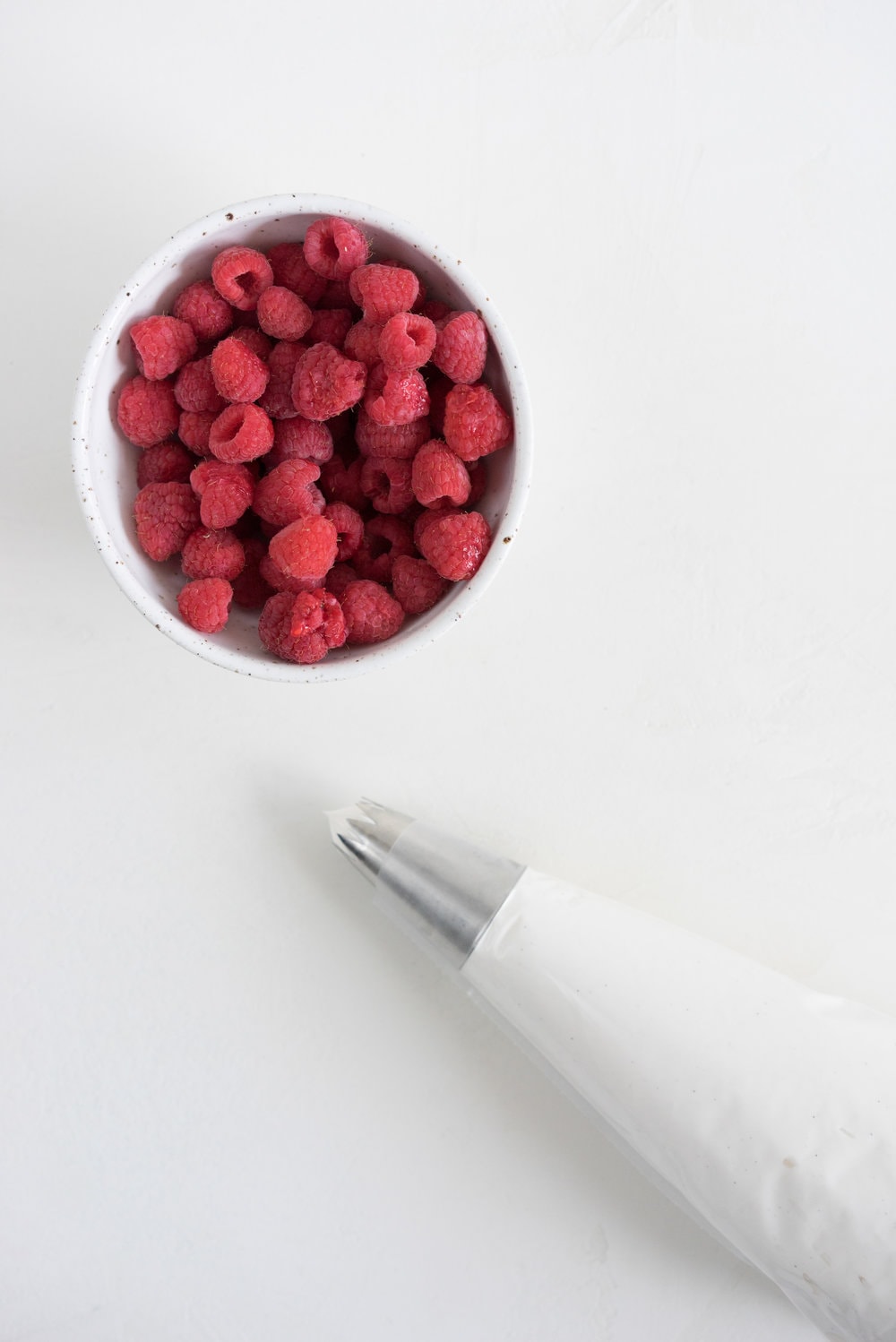 Raspberry and Almond cake - a perfectly dense almond meal cake, lightly scented with lemon, and with a layer of fresh raspberries baked into each layer. Layered with vanilla swiss meringue buttercream and more fresh raspberries. perfect for Mother's day or any other special occasion.