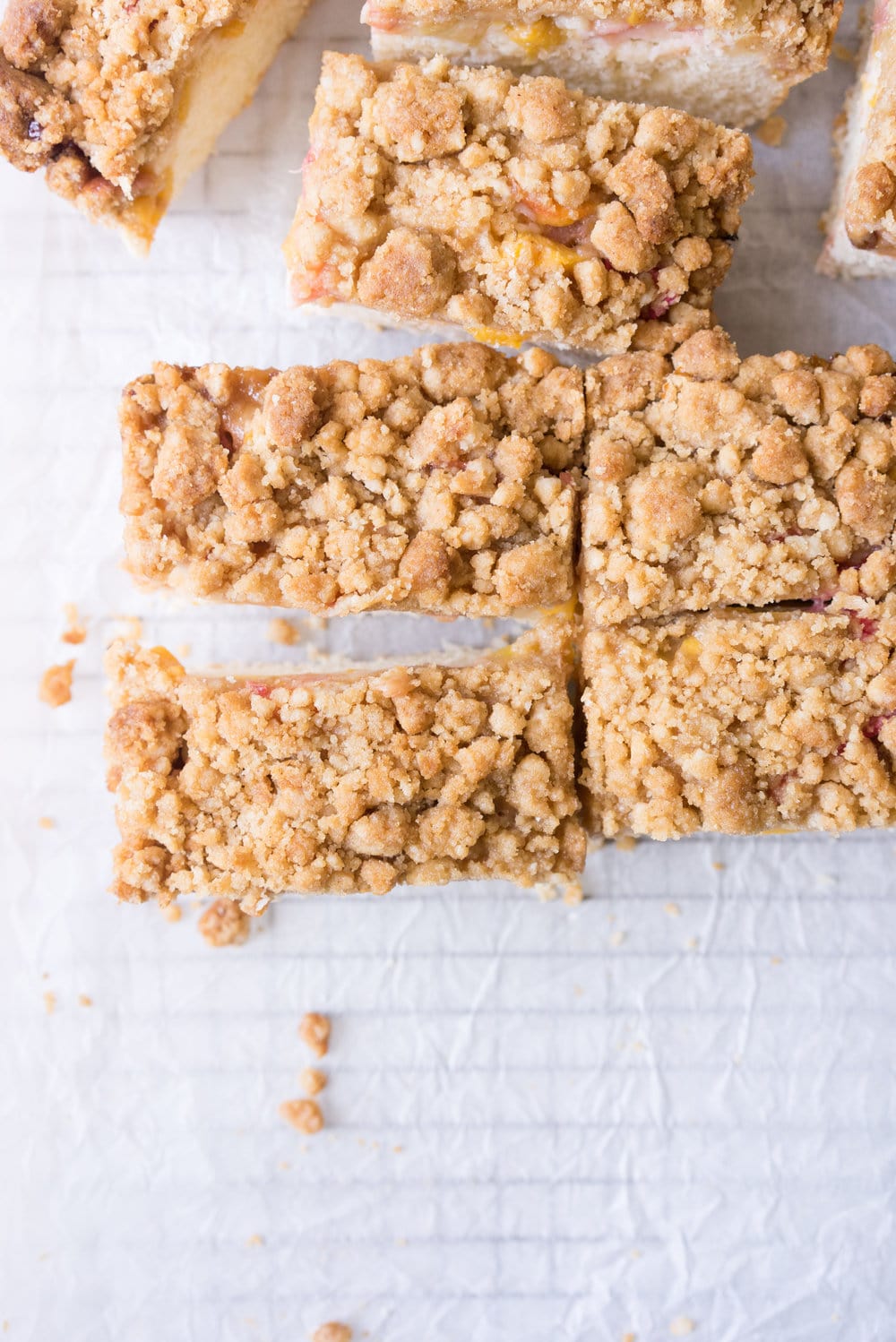 Peach and rhubarb crumb cake with brown butter streusel. This soft vanilla bean cake is covered with chopped fruit, and finished with a toasty, crunchy brown butter streusel.