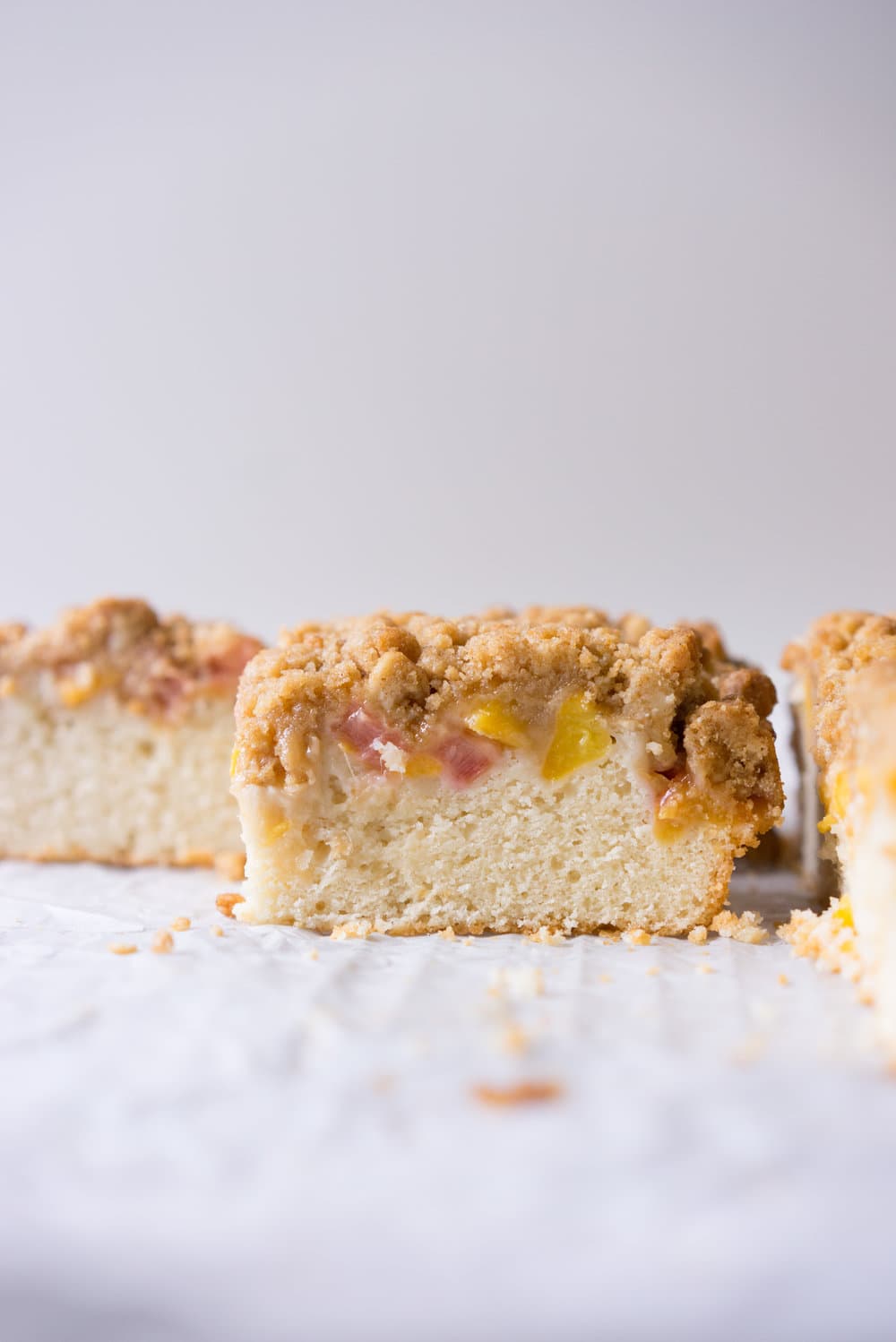 Peach and rhubarb crumb cake with brown butter streusel. This soft vanilla bean cake is covered with chopped fruit, and finished with a toasty, crunchy brown butter streusel.