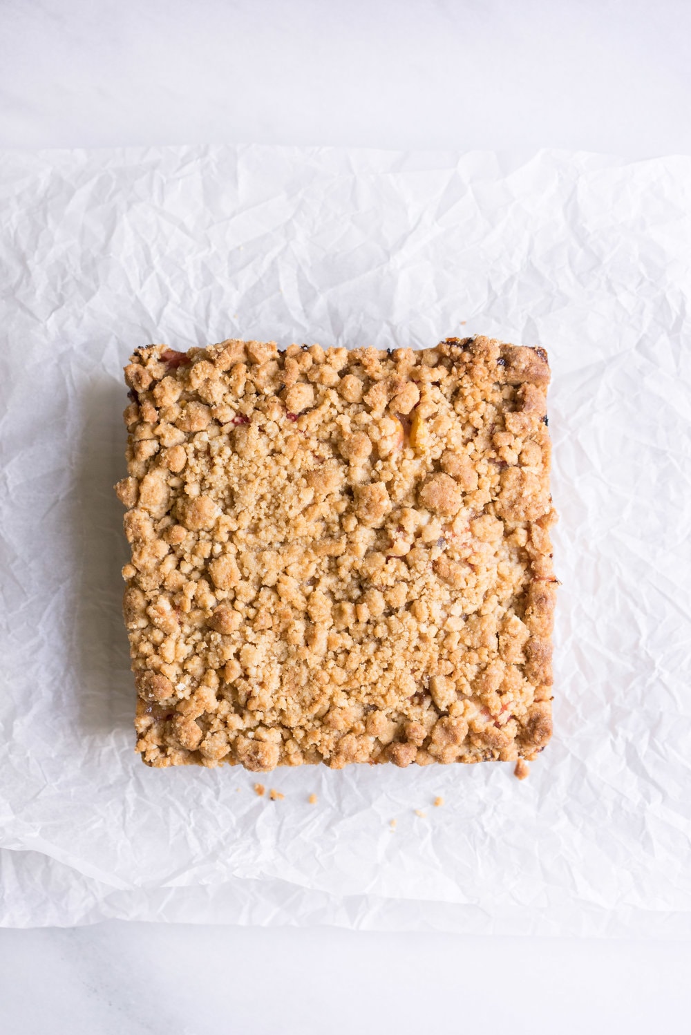 Peach and rhubarb crumb cake with brown butter streusel. This soft vanilla bean cake is covered with chopped fruit, and finished with a toasty, crunchy brown butter streusel.