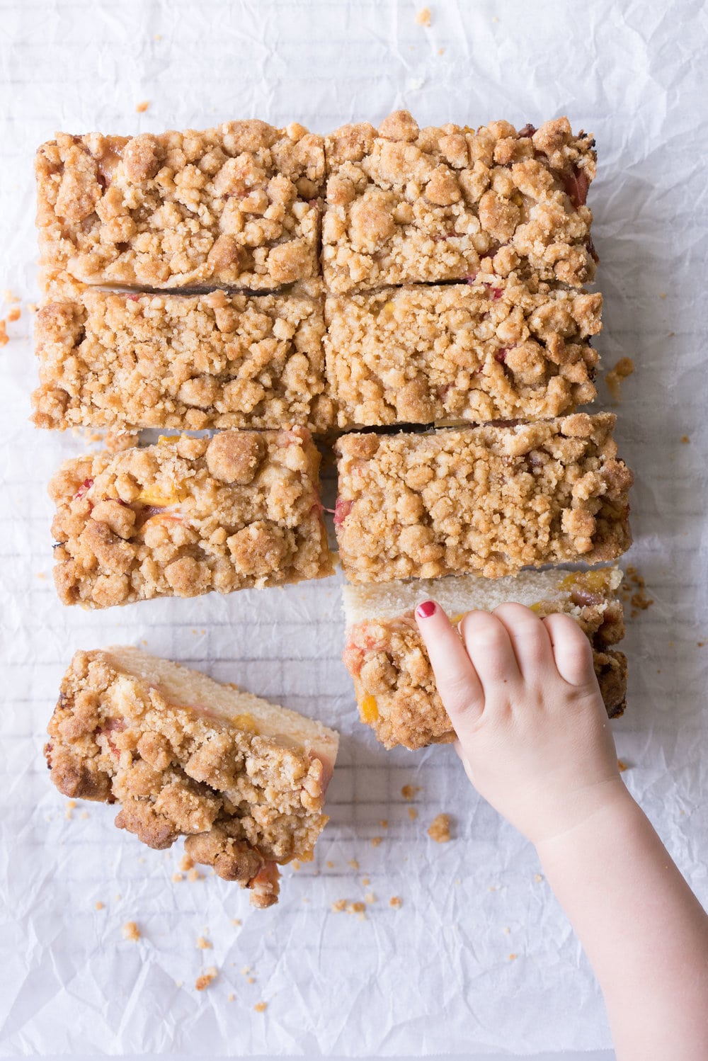 Peach and rhubarb crumb cake with brown butter streusel. This soft vanilla bean cake is covered with chopped fruit, and finished with a toasty, crunchy brown butter streusel.