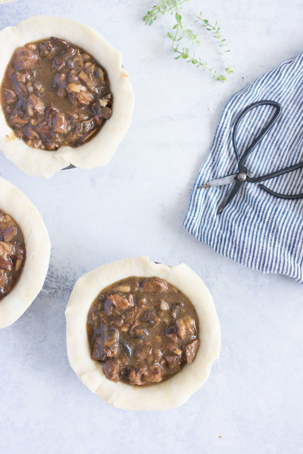 Individual steak and mushroom pies - flaky pastry encases a rich meaty filling with a flavourful gravy