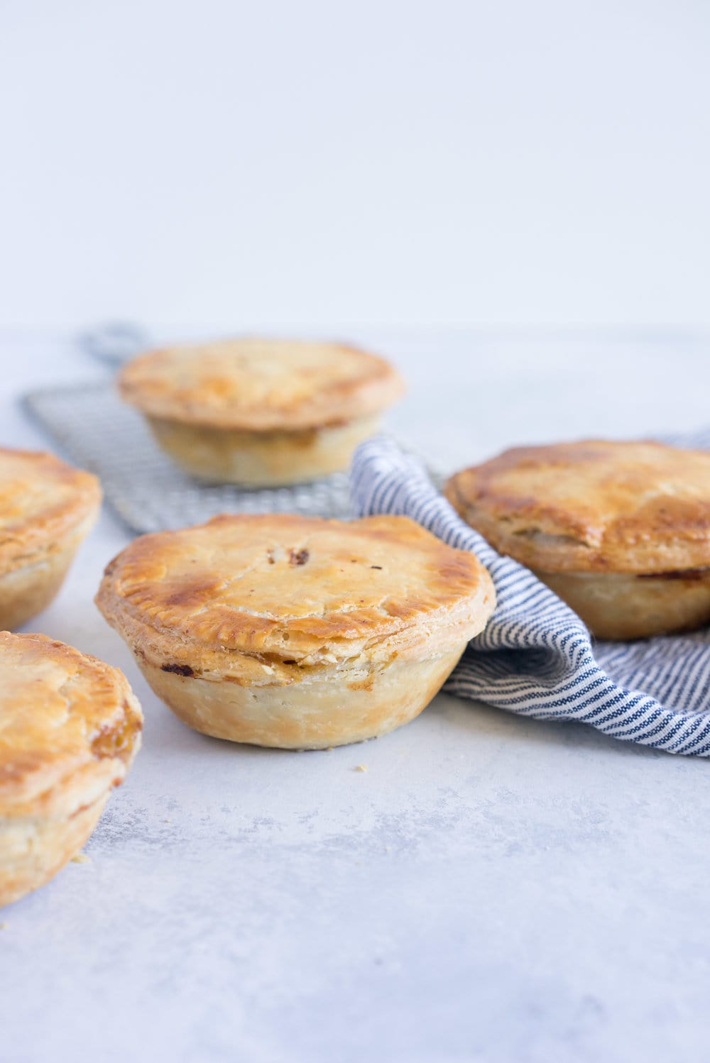 Individual steak and mushroom pies - flaky pastry encases a rich meaty filling with a flavourful gravy