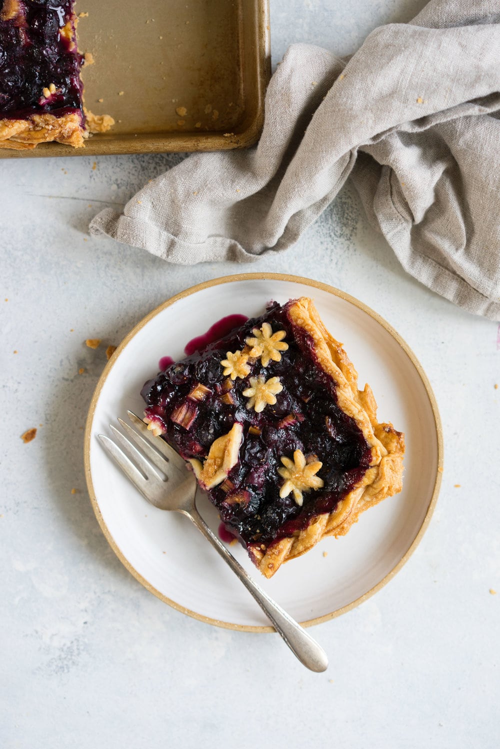 Blueberry and Rhubarb Slab pie - the ideal summer dessert for feeding a crowd! Flaky homemade pie crust is filled with a blueberry rhubarb filling before being topped with fun pie dough decorations then baked to perfection. #blueberry #rhubarb #slabpie #familypie #blueberryrhubarb