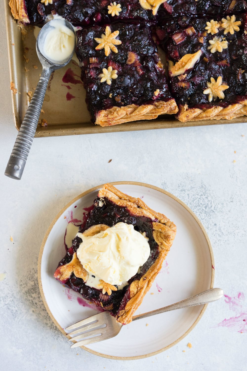 Blueberry and Rhubarb Slab pie - the ideal summer dessert for feeding a crowd! Flaky homemade pie crust is filled with a blueberry rhubarb filling before being topped with fun pie dough decorations then baked to perfection. #blueberry #rhubarb #slabpie #familypie #blueberryrhubarb