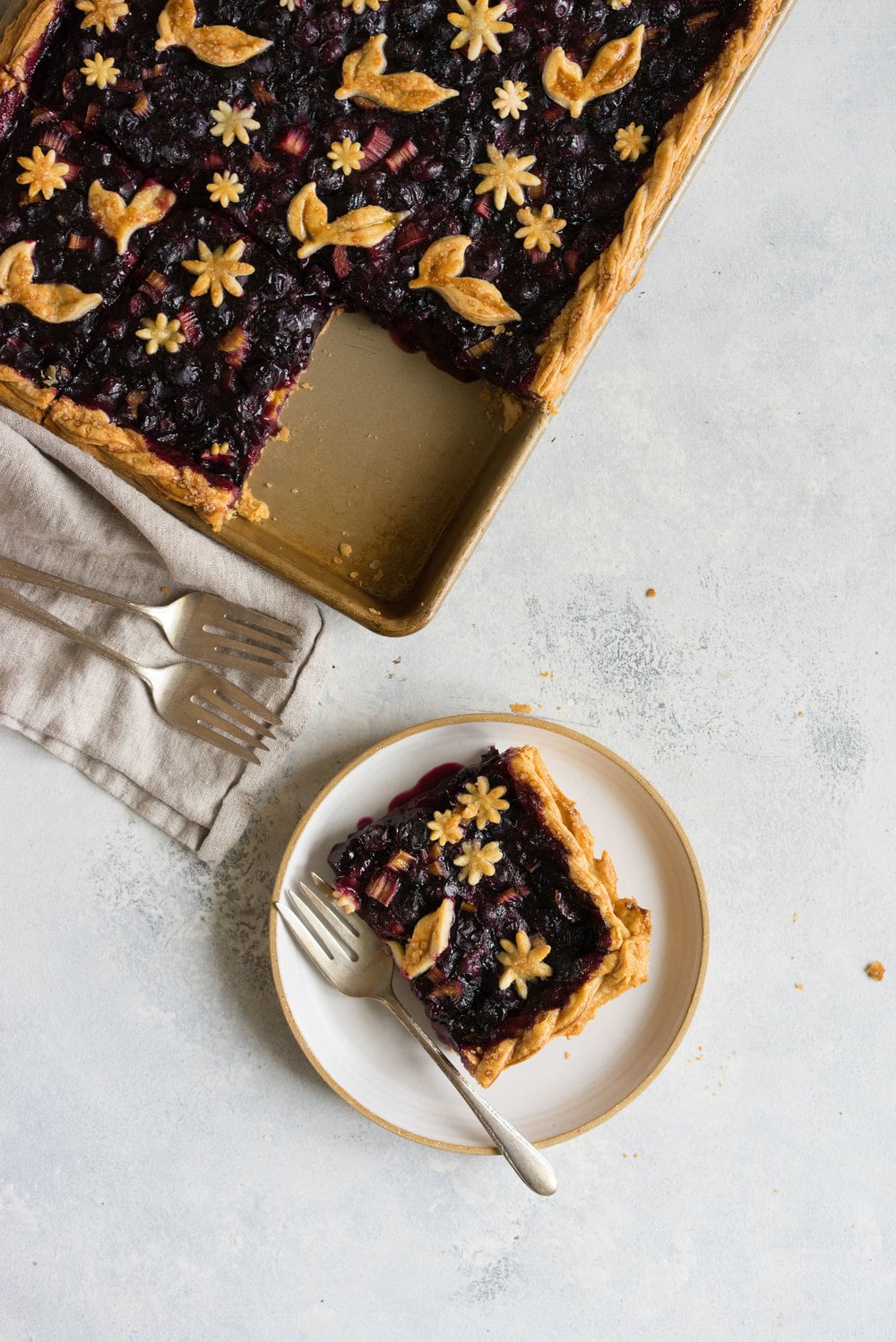 Blueberry and Rhubarb Slab pie - the ideal summer dessert for feeding a crowd! Flaky homemade pie crust is filled with a blueberry rhubarb filling before being topped with fun pie dough decorations then baked to perfection. #blueberry #rhubarb #slabpie #familypie #blueberryrhubarb