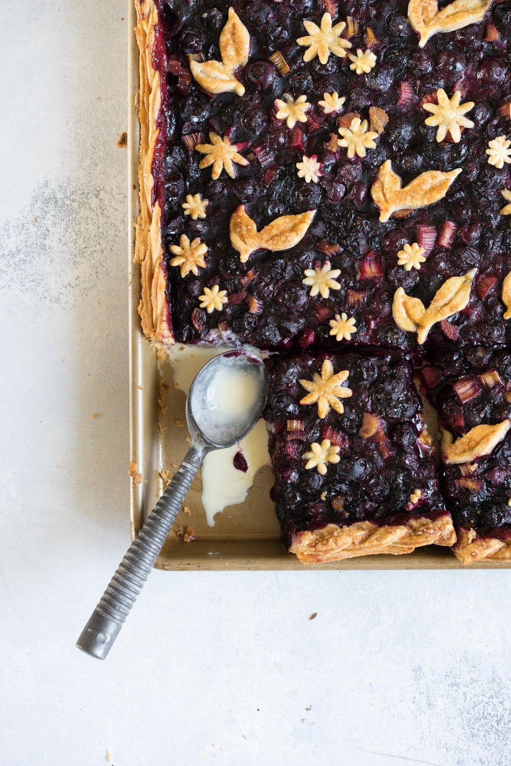 Blueberry and Rhubarb Slab pie - the ideal summer dessert for feeding a crowd! Flaky homemade pie crust is filled with a blueberry rhubarb filling before being topped with fun pie dough decorations then baked to perfection. #blueberry #rhubarb #slabpie #familypie #blueberryrhubarb