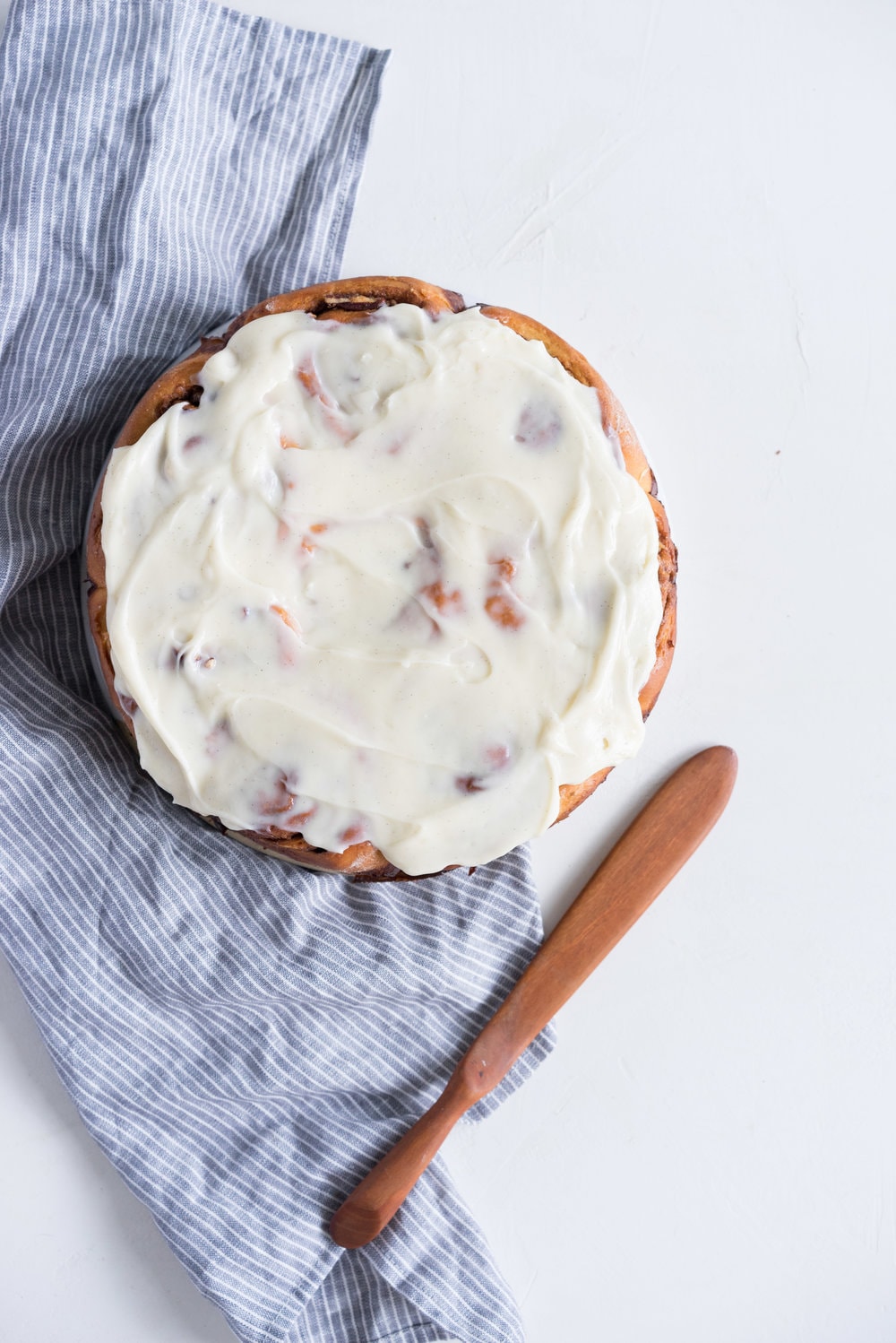 Overnight Cinnamon Buns with Cream Cheese Frosting - Pillowy brioche that is prepared the night before, then rolled out the next morning, stuffed with cinnamon sugar and toasted peanuts, then smothered in cream cheese frosting while still warm. The perfect treat to please a crowd. #cinnamonrolls #overnight #brioche