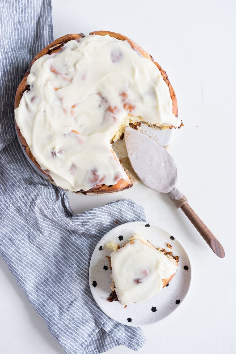 Overnight Cinnamon Buns with Cream Cheese Frosting - Pillowy brioche that is prepared the night before, then rolled out the next morning, stuffed with cinnamon sugar and toasted peanuts, then smothered in cream cheese frosting while still warm. The perfect treat to please a crowd. #cinnamonrolls #overnight #brioche