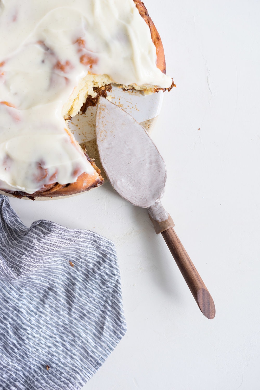 Overnight Cinnamon Buns with Cream Cheese Frosting - Pillowy brioche that is prepared the night before, then rolled out the next morning, stuffed with cinnamon sugar and toasted peanuts, then smothered in cream cheese frosting while still warm. The perfect treat to please a crowd. #cinnamonrolls #overnight #brioche
