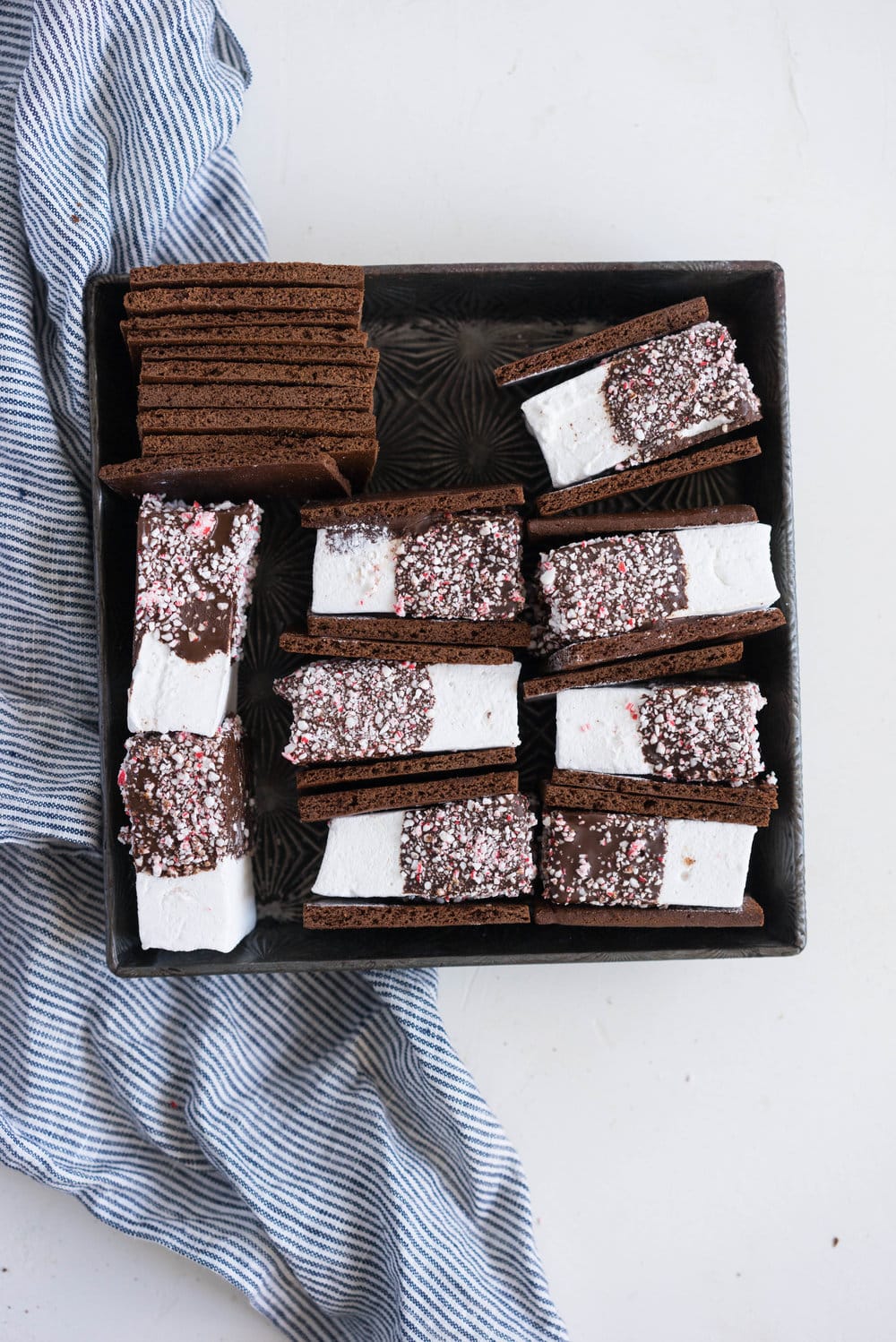 Peppermint S'mores with Chocolate Graham Crackers from Cloudy Kitchen. Puffy peppermint marshmallows are dipped in chocolate and rolled in candy canes, before being sandwiched between two chocolate graham crackers. A christmas twist on a holiday favourite