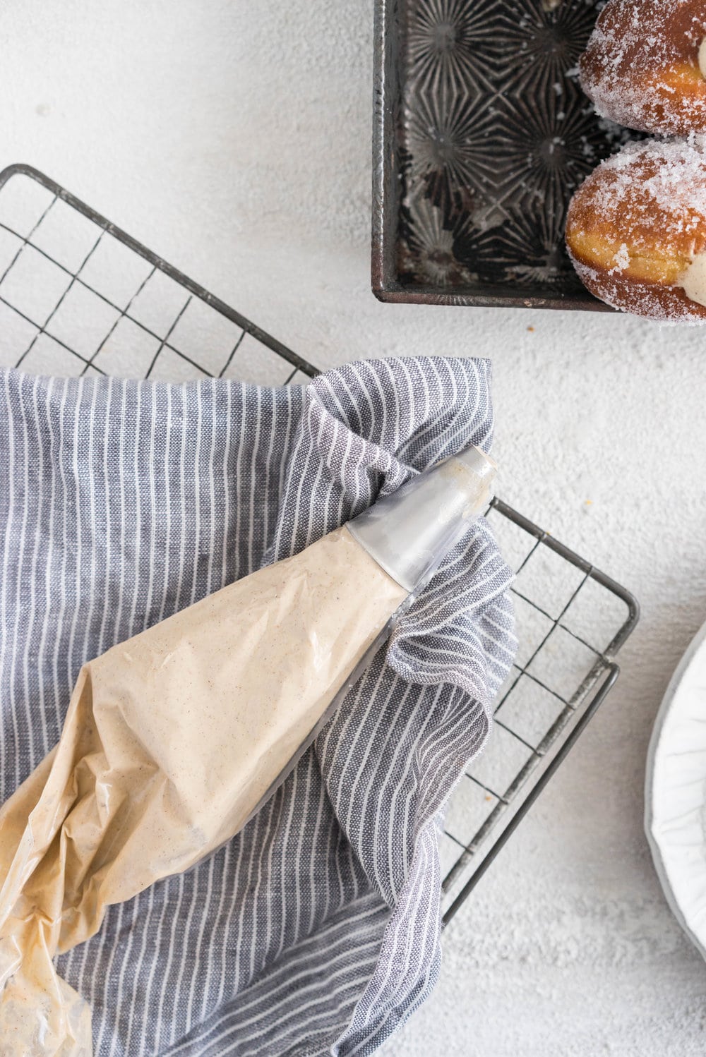 Gingerbread doughnuts with a spiced brown sugar diplomat cream. Pillowy brioche dough, spiced lightly with ginger and molasses, are stuffed with a light and creamy filling which is loaded with christmas spice. A perfect little package of holiday cheer