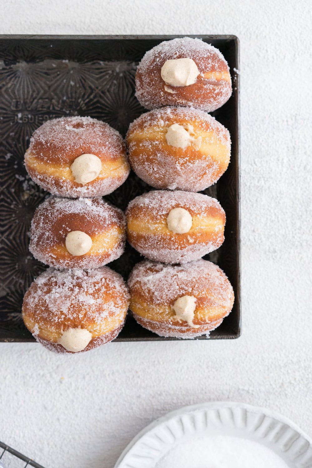 Gingerbread doughnuts with a spiced brown sugar diplomat cream. Pillowy brioche dough, spiced lightly with ginger and molasses, are stuffed with a light and creamy filling which is loaded with christmas spice. A perfect little package of holiday cheer