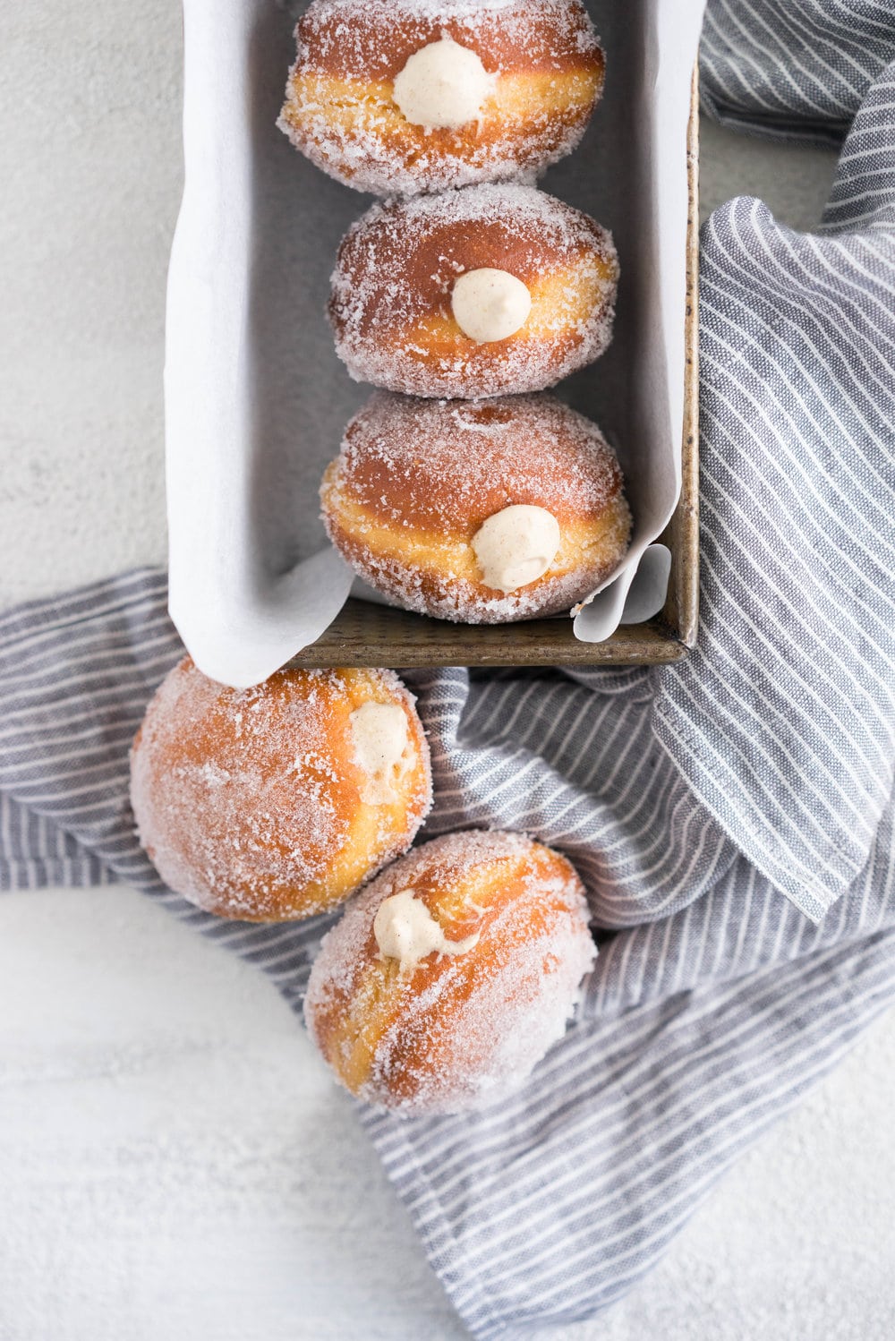 Gingerbread doughnuts with a spiced brown sugar diplomat cream. Pillowy brioche dough, spiced lightly with ginger and molasses, are stuffed with a light and creamy filling which is loaded with christmas spice. A perfect little package of holiday cheer