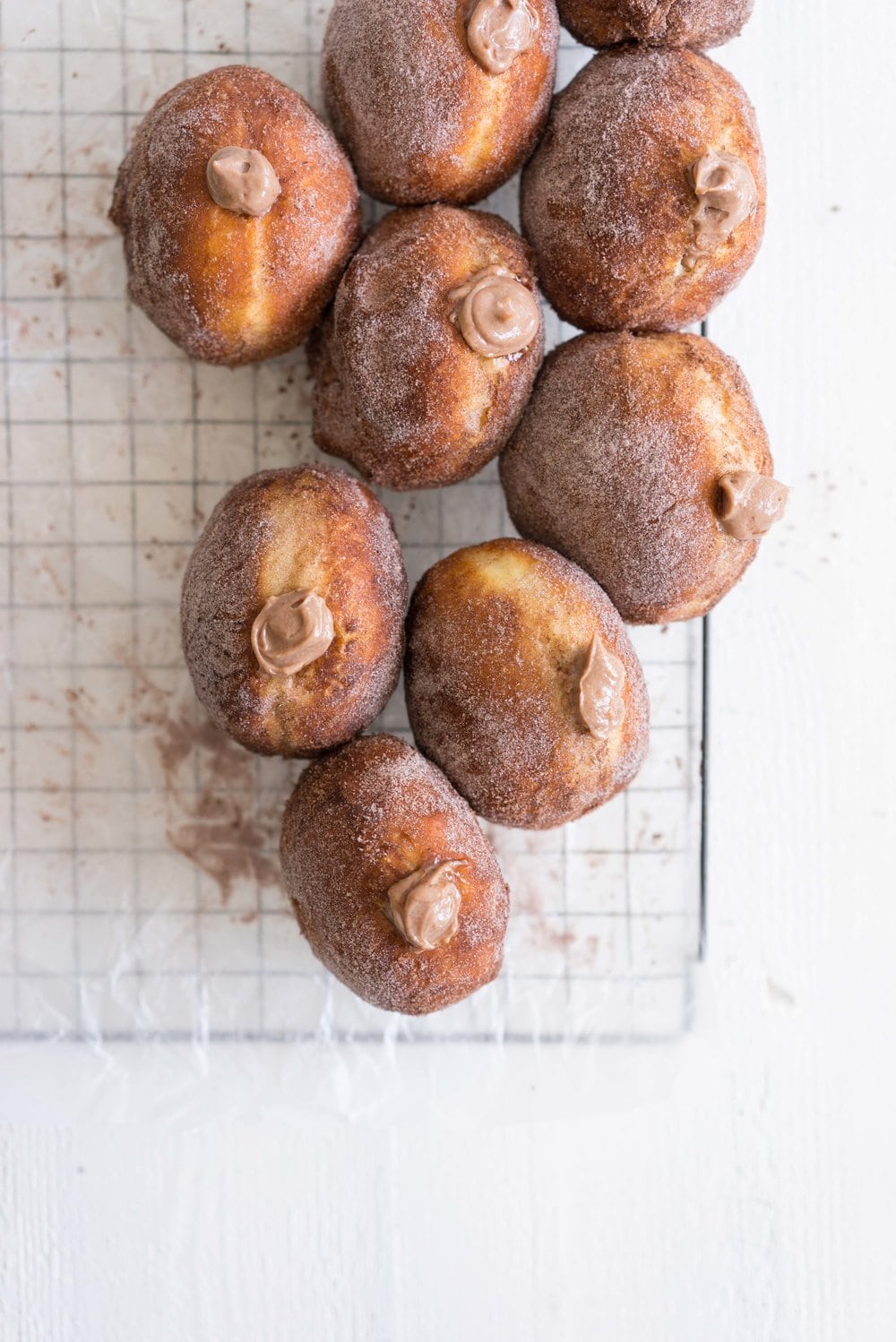 Brioche doughnuts filled with chocolate tahini pastry cream and topped with Halva