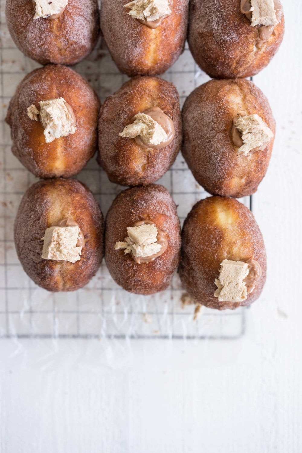 Brioche doughnuts filled with chocolate tahini pastry cream and topped with Halva