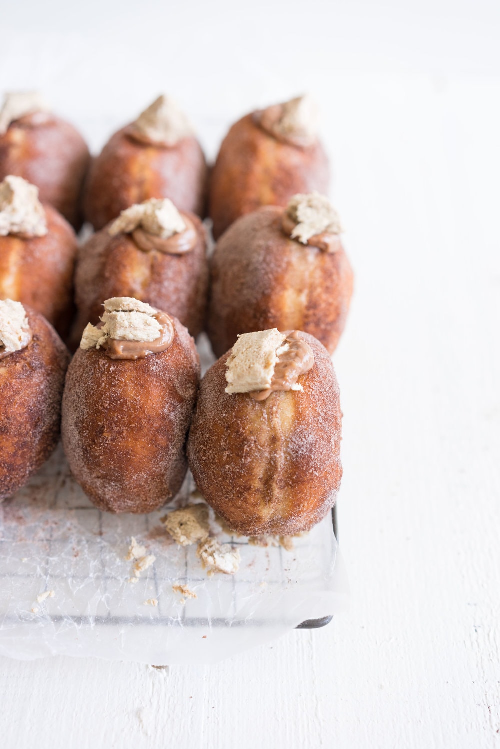 Brioche doughnuts filled with chocolate tahini pastry cream and topped with Halva
