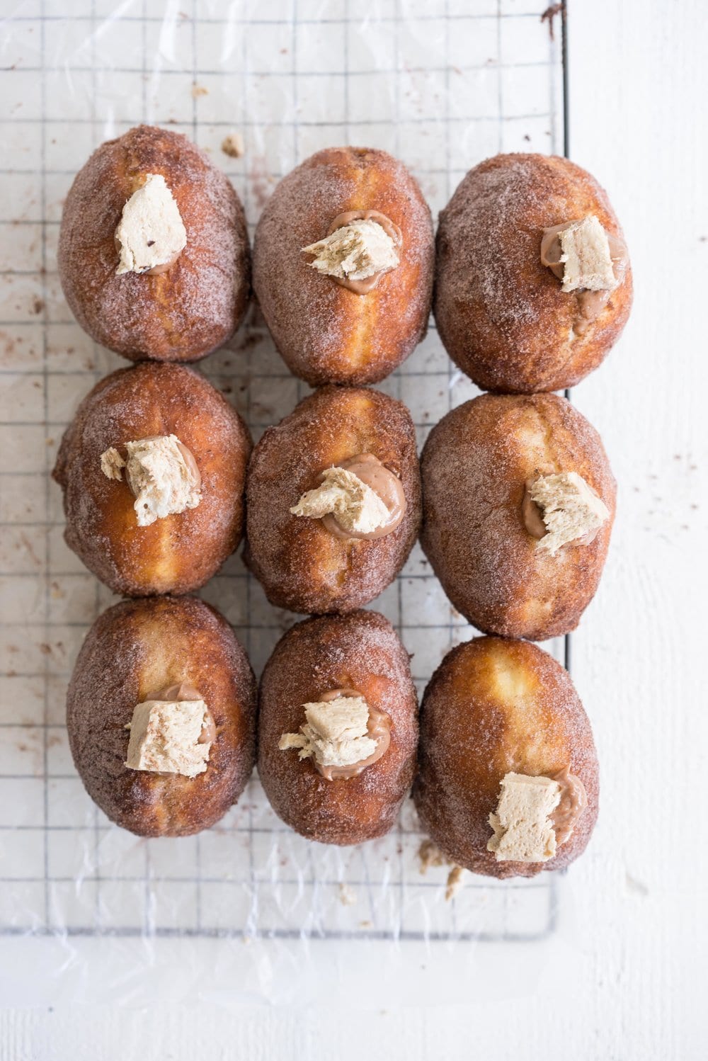 Brioche doughnuts filled with chocolate tahini pastry cream and topped with Halva