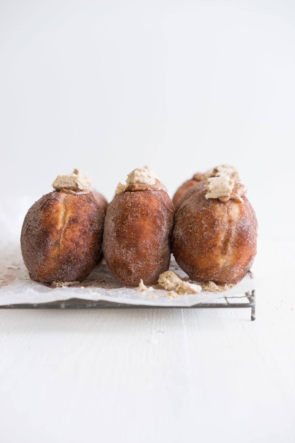 Brioche doughnuts filled with chocolate tahini pastry cream and topped with Halva