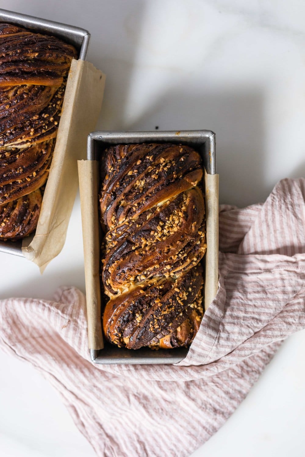 Chocolate Hazelnut Babka - fluffy brioche dough is rolled out and spread with a homemade hazelnut chocolate spread, sprinkled with chopped toasted walnuts, and rolled into swirly chocolatey loaves. The result is perfect for a coffee break, or an indulgent wee breakfast.
