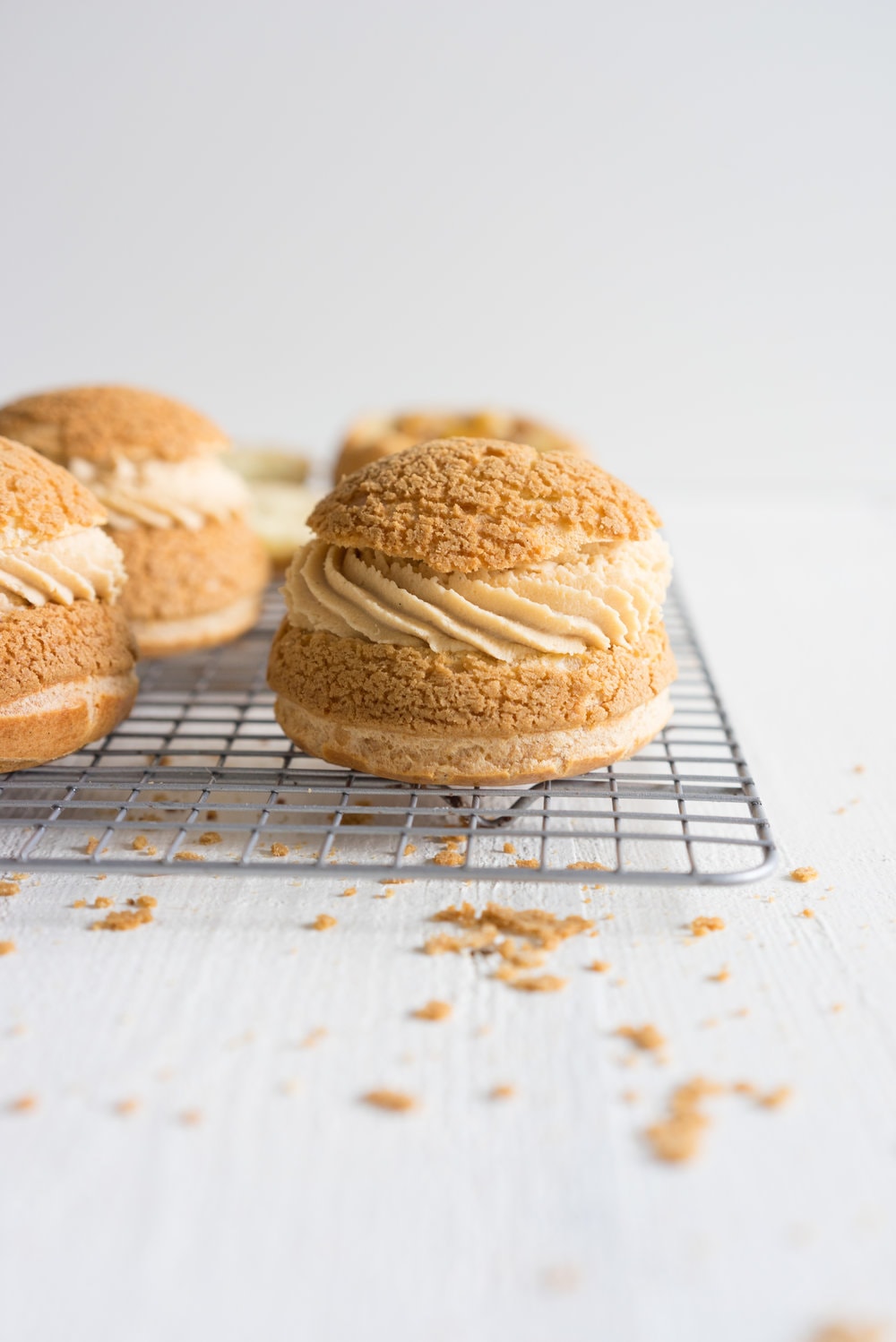 Choux au Craquelin (Cream Puffs) with Caramelised White Chocolate Whipping Ganache, Caramelised Bananas, and Pecan Brittle