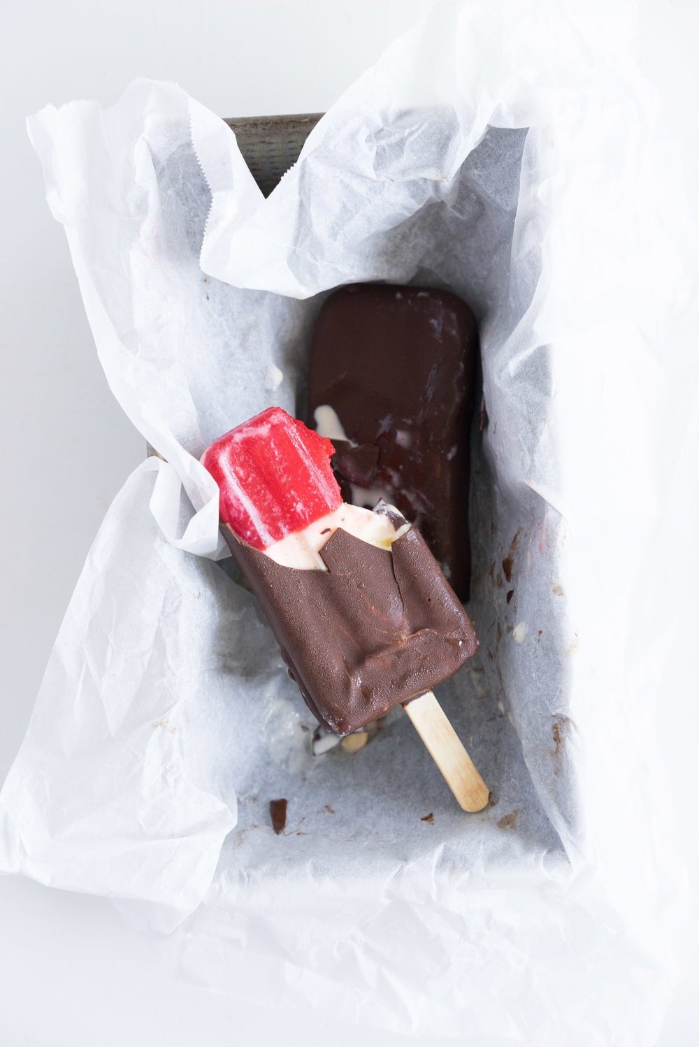 A homemade take on the New Zealand Childhood favourite Jelly Tips - the top of ice cream pops are filled with jelly before being topped up with creamy vanilla bean ice cream, then dipped in a dark chocolate topping.