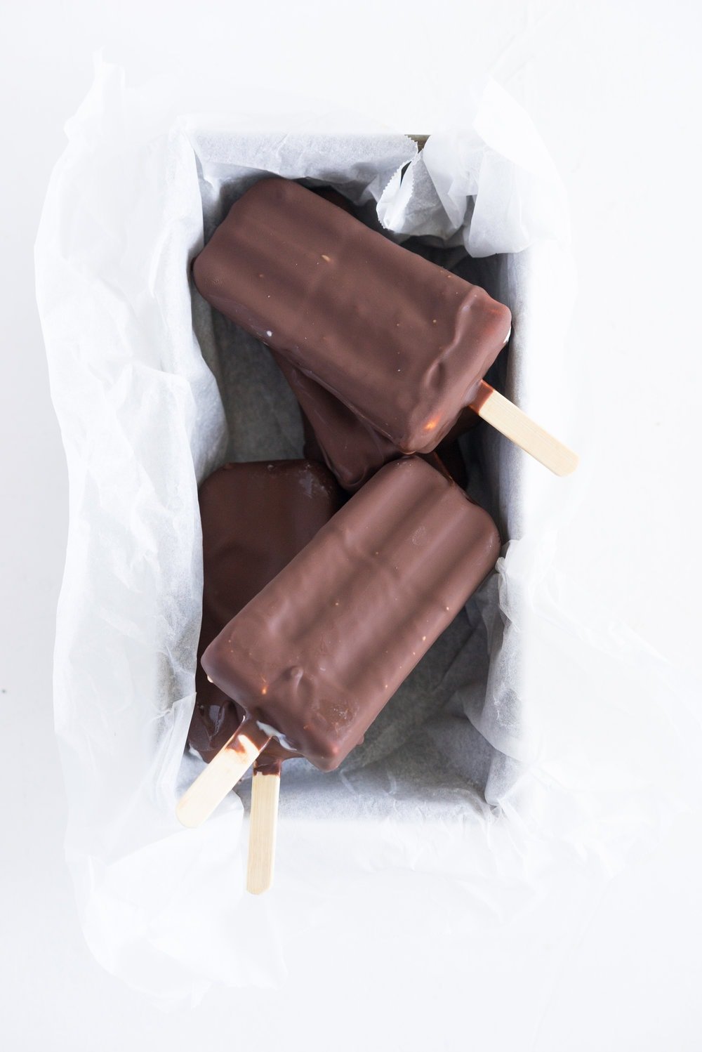 A homemade take on the New Zealand Childhood favourite Jelly Tips - the top of ice cream pops are filled with jelly before being topped up with creamy vanilla bean ice cream, then dipped in a dark chocolate topping.