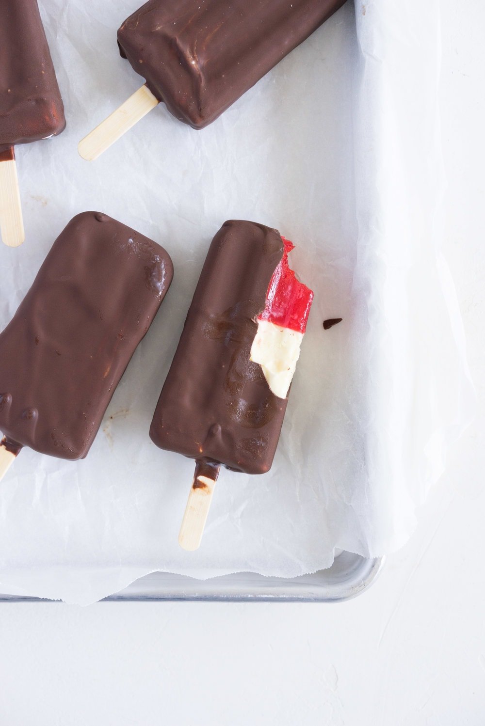 A homemade take on the New Zealand Childhood favourite Jelly Tips - the top of ice cream pops are filled with jelly before being topped up with creamy vanilla bean ice cream, then dipped in a dark chocolate topping.