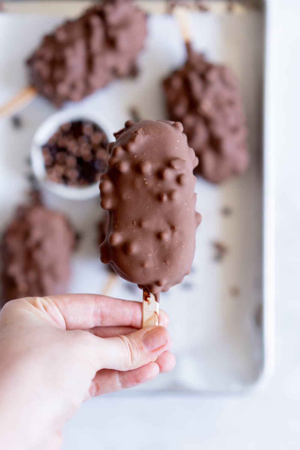 Rocky Road Ice Cream Pops by Cloudy Kitchen. Rich Chocolate ice cream is studded with marshmallow and turkish delight pieces, frozen into a pop, then dipped in creamy milk chocolate with crispy pearls. #Rockyroad #icecreampop #popsicle #cloudykitchen