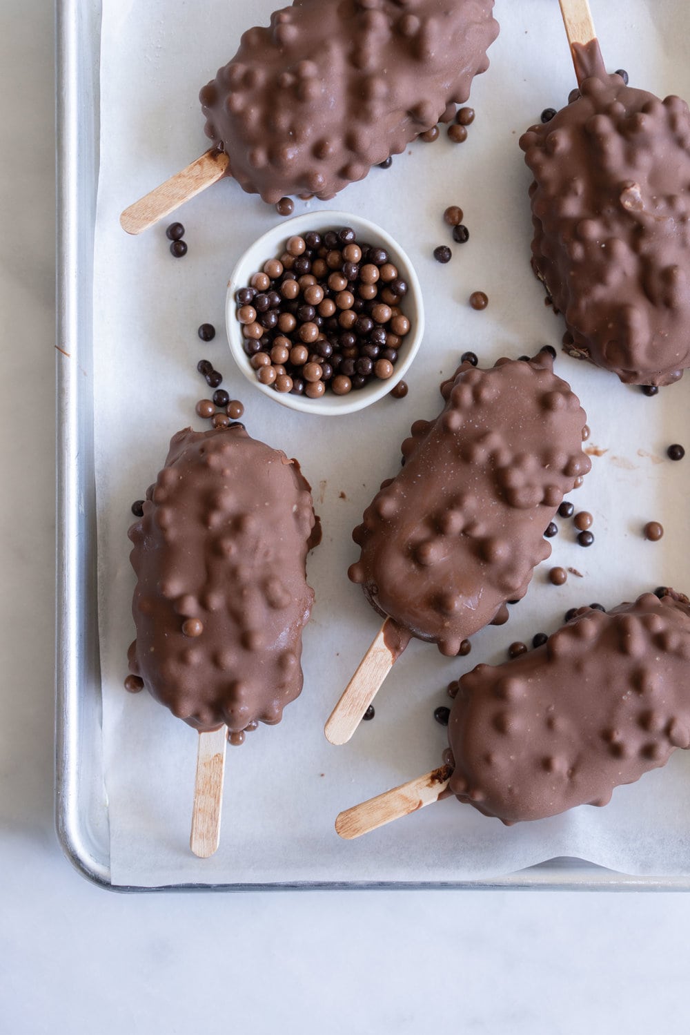 Rocky Road Ice Cream Pops by Cloudy Kitchen. Rich Chocolate ice cream is studded with marshmallow and turkish delight pieces, frozen into a pop, then dipped in creamy milk chocolate with crispy pearls. #Rockyroad #icecreampop #popsicle #cloudykitchen