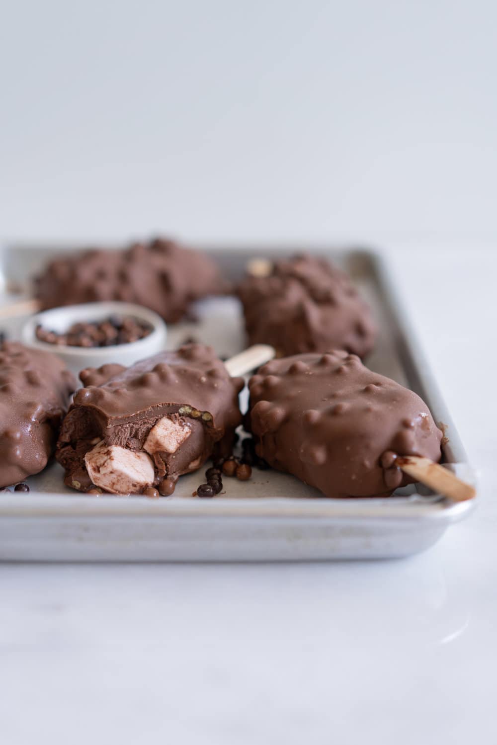 Rocky Road Ice Cream Pops by Cloudy Kitchen. Rich Chocolate ice cream is studded with marshmallow and turkish delight pieces, frozen into a pop, then dipped in creamy milk chocolate with crispy pearls. #Rockyroad #icecreampop #popsicle #cloudykitchen