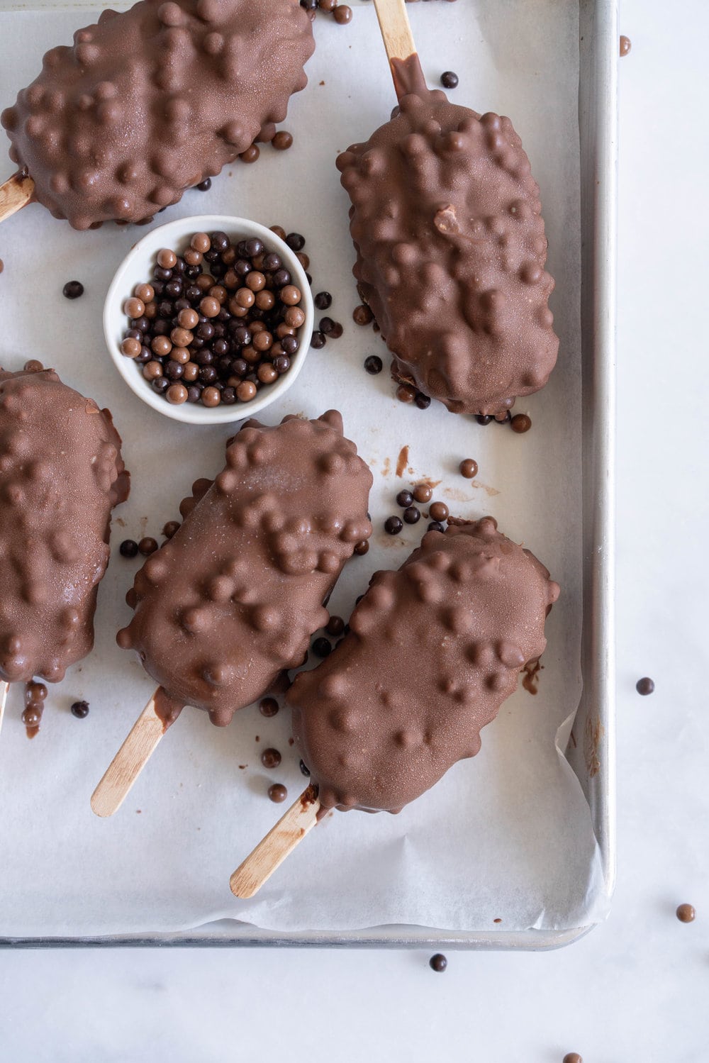 Rocky Road Ice Cream Pops by Cloudy Kitchen. Rich Chocolate ice cream is studded with marshmallow and turkish delight pieces, frozen into a pop, then dipped in creamy milk chocolate with crispy pearls. #Rockyroad #icecreampop #popsicle #cloudykitchen
