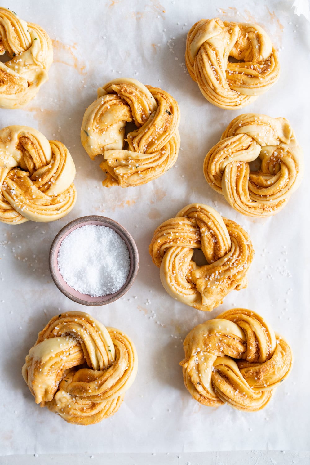 Fluffy Brioche knots filled with Roasted Garlic, Tomato and Ricotta Pesto. Rolled up and twisted into knots, and baked to golden, puffy perfection. Perfect on their own or as an addition to a lunch or alongside a bowl of soup. #brioche #briocheknot #pestobrioche