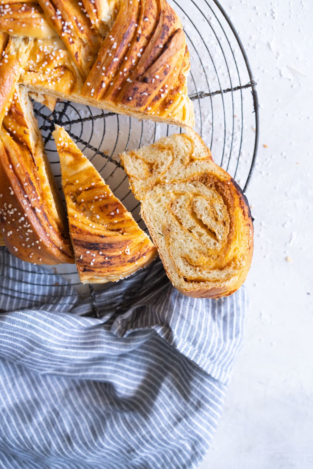 Fluffy Brioche filled with Roasted Garlic, Tomato and Ricotta Pesto. Rolled up and twisted into a knot, and baked to golden, puffy perfection. Perfect on it's own or as an addition to a lunch or alongside a bowl of soup. #brioche #briocheknot #pestobrioche