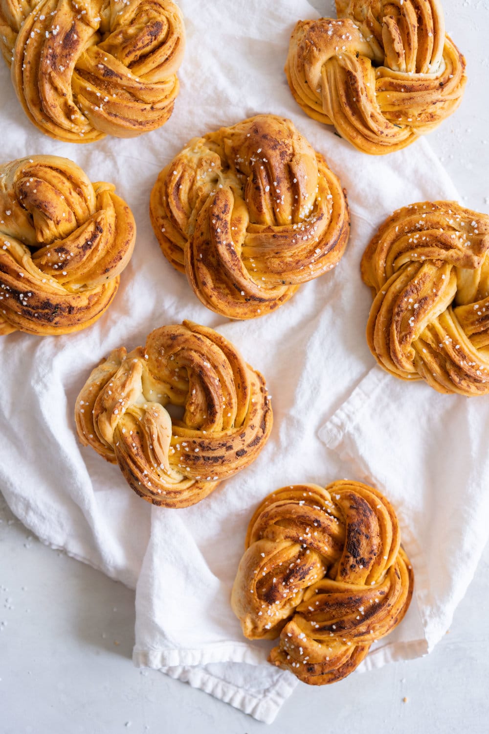 Fluffy Brioche knots filled with Roasted Garlic, Tomato and Ricotta Pesto. Rolled up and twisted into knots, and baked to golden, puffy perfection. Perfect on their own or as an addition to a lunch or alongside a bowl of soup. #brioche #briocheknot #pestobrioche