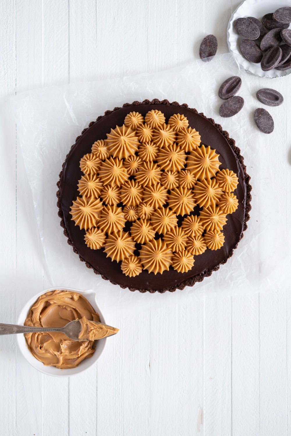 Dark Chocolate Peanut Butter Tart with Peanut Butter Whipped Cream - a chocolate graham cracker crust is topped with a silky dark chocolate peanut butter filling and finished with a creamy peanut butter whipped cream. Everyone needs a recipe like this up their sleeve to wow their friends. Easy to make ahead, and always a crowd pleaser. #chocolatetart #peanutbuttertart #chocolate #peanutbutter
