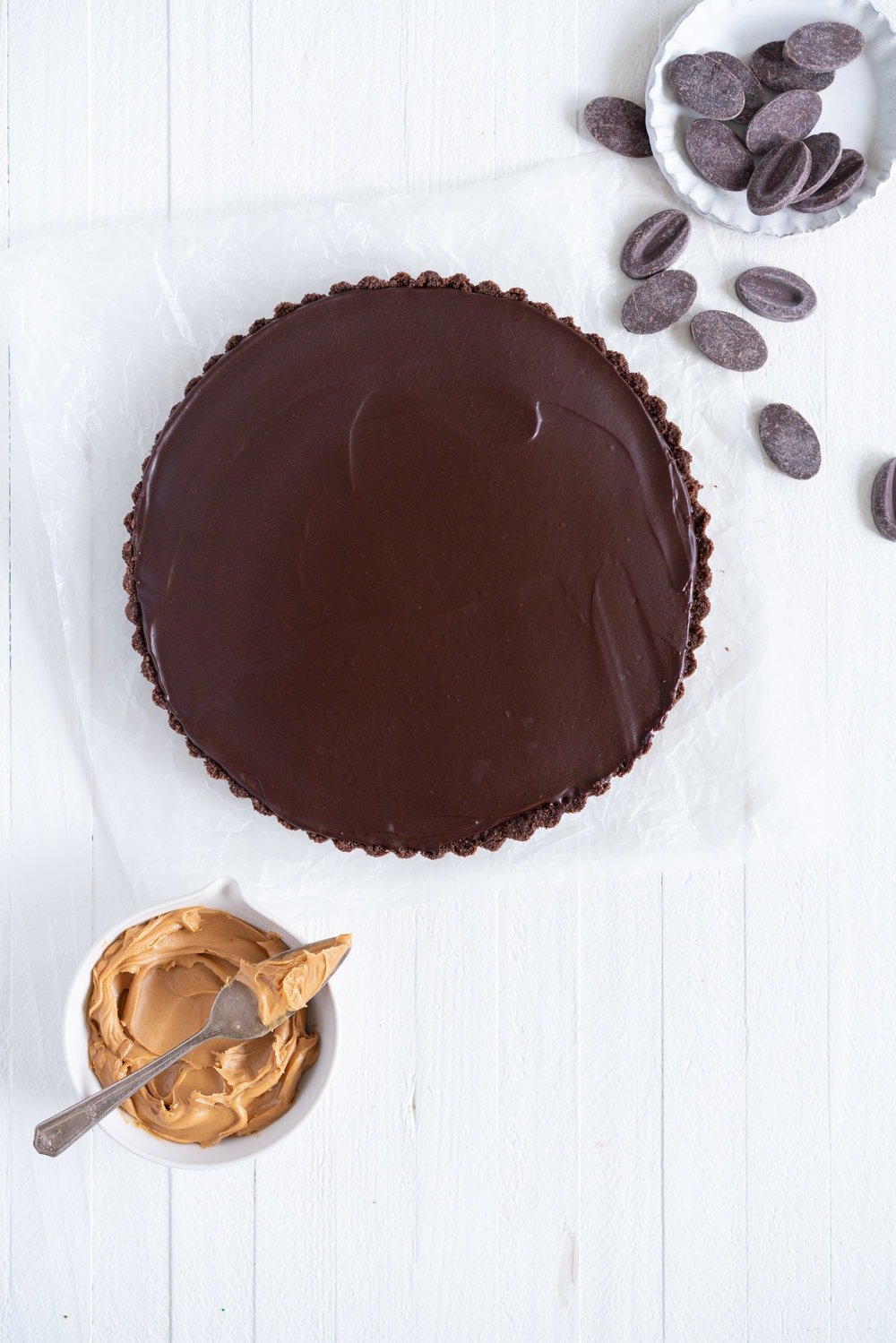 Dark Chocolate Peanut Butter Tart with Peanut Butter Whipped Cream - a chocolate graham cracker crust is topped with a silky dark chocolate peanut butter filling and finished with a creamy peanut butter whipped cream. Everyone needs a recipe like this up their sleeve to wow their friends. Easy to make ahead, and always a crowd pleaser. #chocolatetart #peanutbuttertart #chocolate #peanutbutter