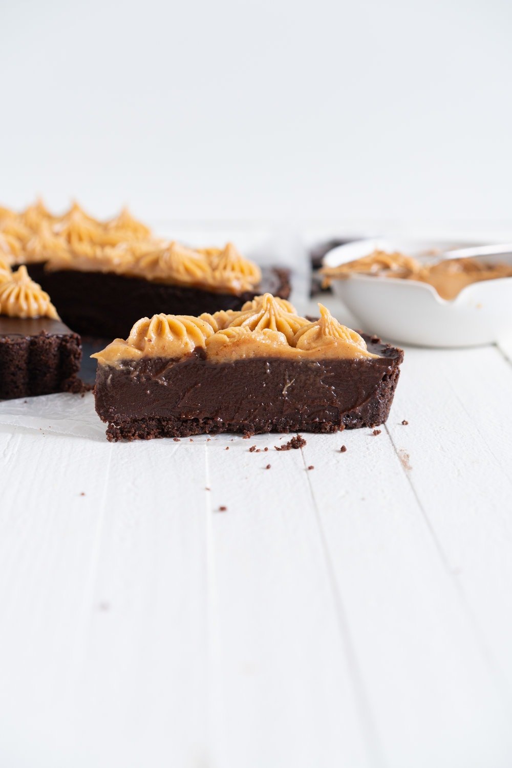 Dark Chocolate Peanut Butter Tart with Peanut Butter Whipped Cream - a chocolate graham cracker crust is topped with a silky dark chocolate peanut butter filling and finished with a creamy peanut butter whipped cream. Everyone needs a recipe like this up their sleeve to wow their friends. Easy to make ahead, and always a crowd pleaser. #chocolatetart #peanutbuttertart #chocolate #peanutbutter