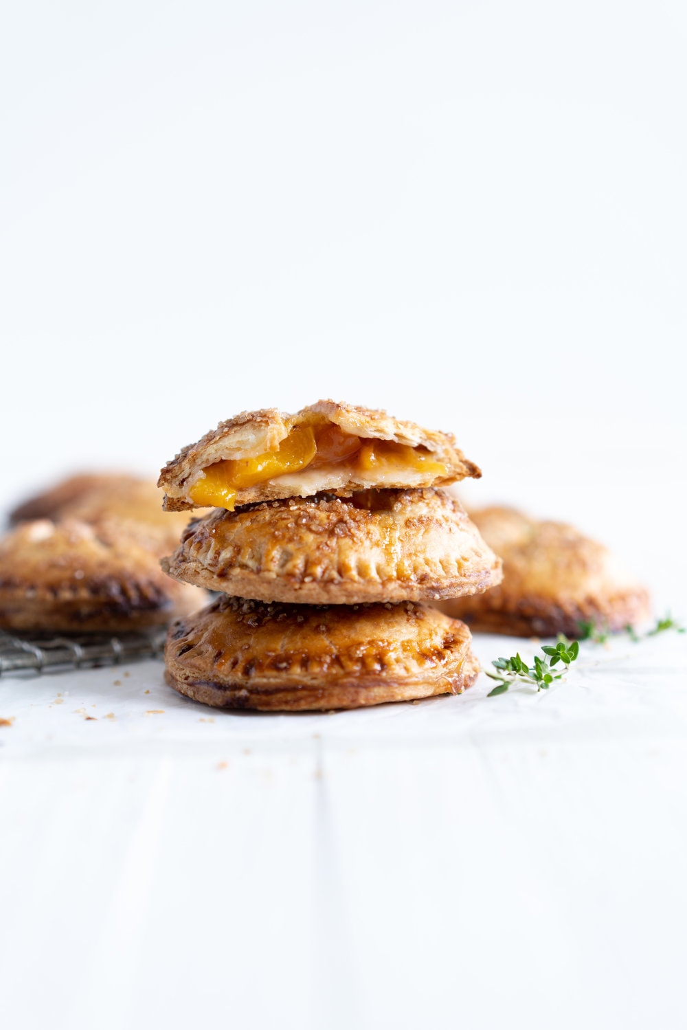 Peach and Thyme Hand pies - sweet, ripe peaches are enveloped in a tender flaky pie crust, and enhanced with the delicate flavour of thyme. #handpies #peachpies #pie #baking #peach #thyme