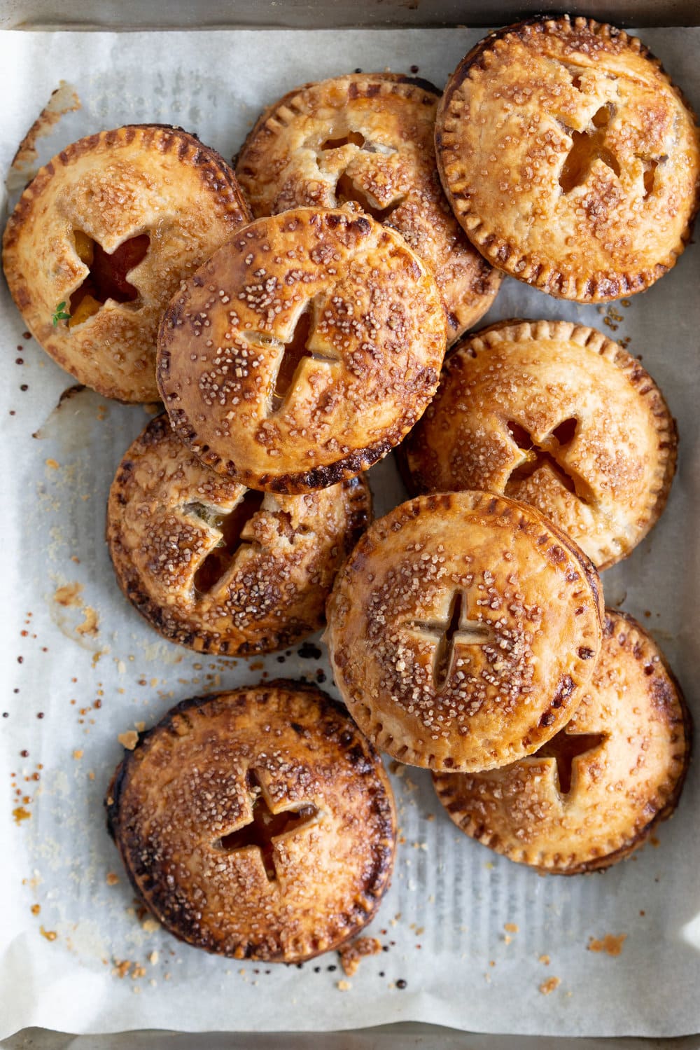 Peach and Thyme Hand pies - sweet, ripe peaches are enveloped in a tender flaky pie crust, and enhanced with the delicate flavour of thyme. #handpies #peachpies #pie #baking #peach #thyme